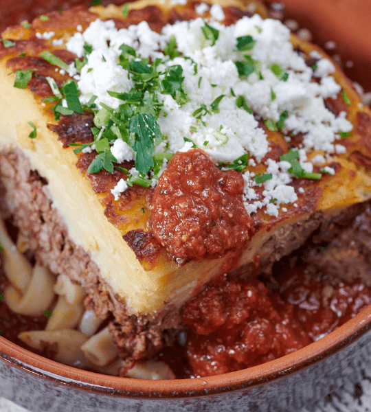 Acropolis Greek Taverna - Moussaka Yia Yia's Recipe!: Potatoes, Eggplant, Zucchini, Ground Beef and Onions Baked with Creamy Bechamel Over Fresh Tomato Sauce. Topped with Feta Cheese. Choice of Beef or Vegetarian.
