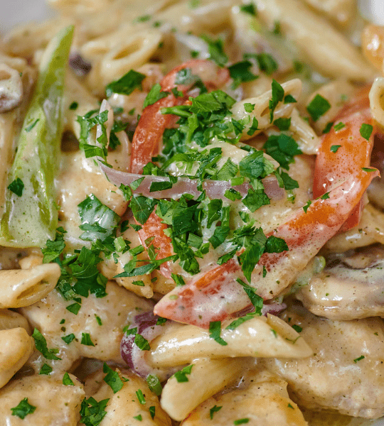 Acropolis Greek Taverna - Pasta Santorini: Penne Pasta in a Creamy Santorini Lemon Wine Sauce Mixed with Mushrooms, Onions, Roasted Red Peppers, Pesto, and Green Peppers. Topped with Shaved Parmesan Cheese.