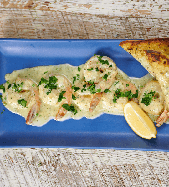 Acropolis Greek Taverna - Shrimp Tinos: Sauteed Shrimp in a Santorini Lemon Garlic Wine Sauce Topped with Shaved Parmesan Cheese. Served with Garlic Bread.