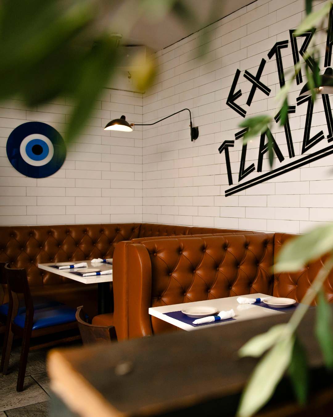 Acropolis Greek Taverna booth seating with Tzatziki signage and traditional Greek decor.