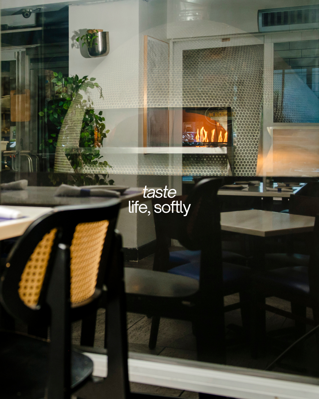 Acropolis Greek Taverna interior with fireplace and dining area, showcasing authentic Greek dining experience.