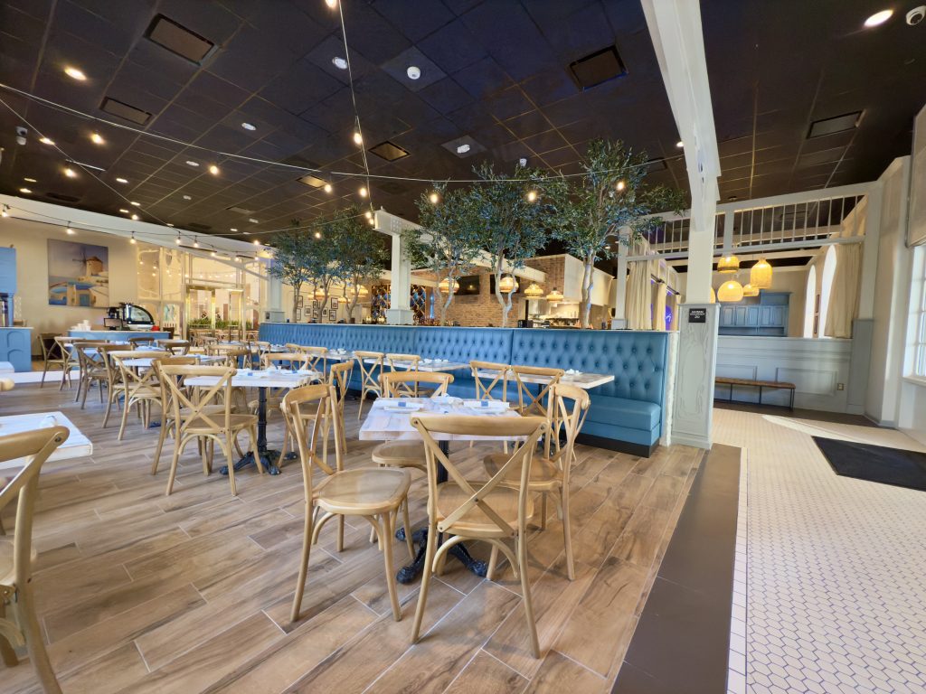 Authentic Greek restaurant interior in Orlando with blue booths and wooden tables.