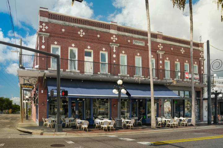Acropolis Greek Taverna in Ybor City, Tampa, with outdoor seating and a blue awning.
