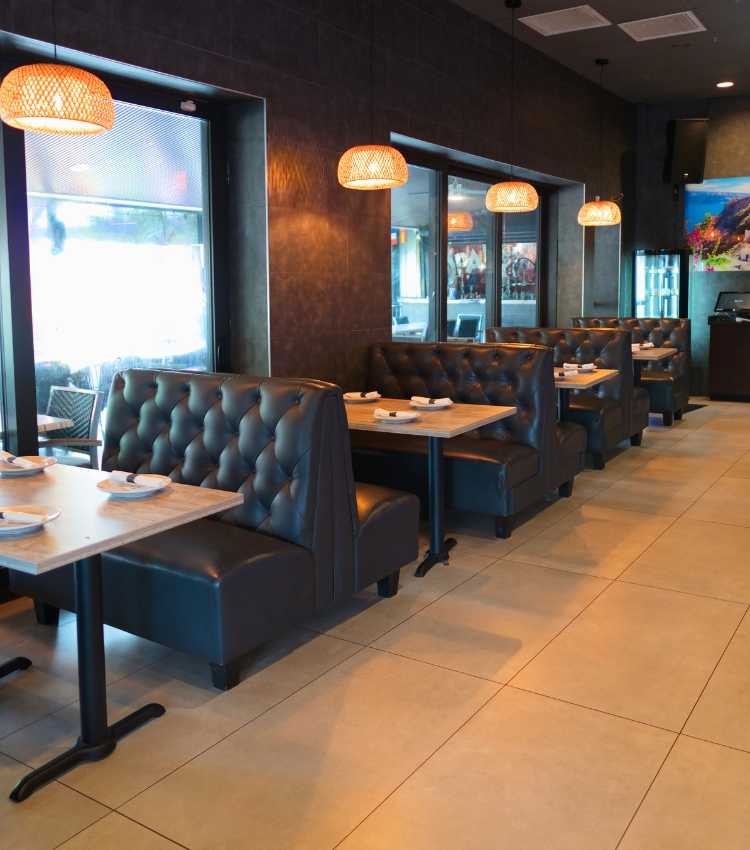 Acropolis Greek Taverna main dining room with booth seating and tables.