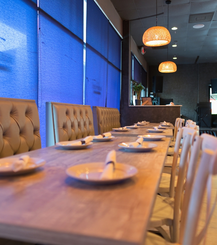 Acropolis Greek Taverna main dining room with set tables and booth seating.